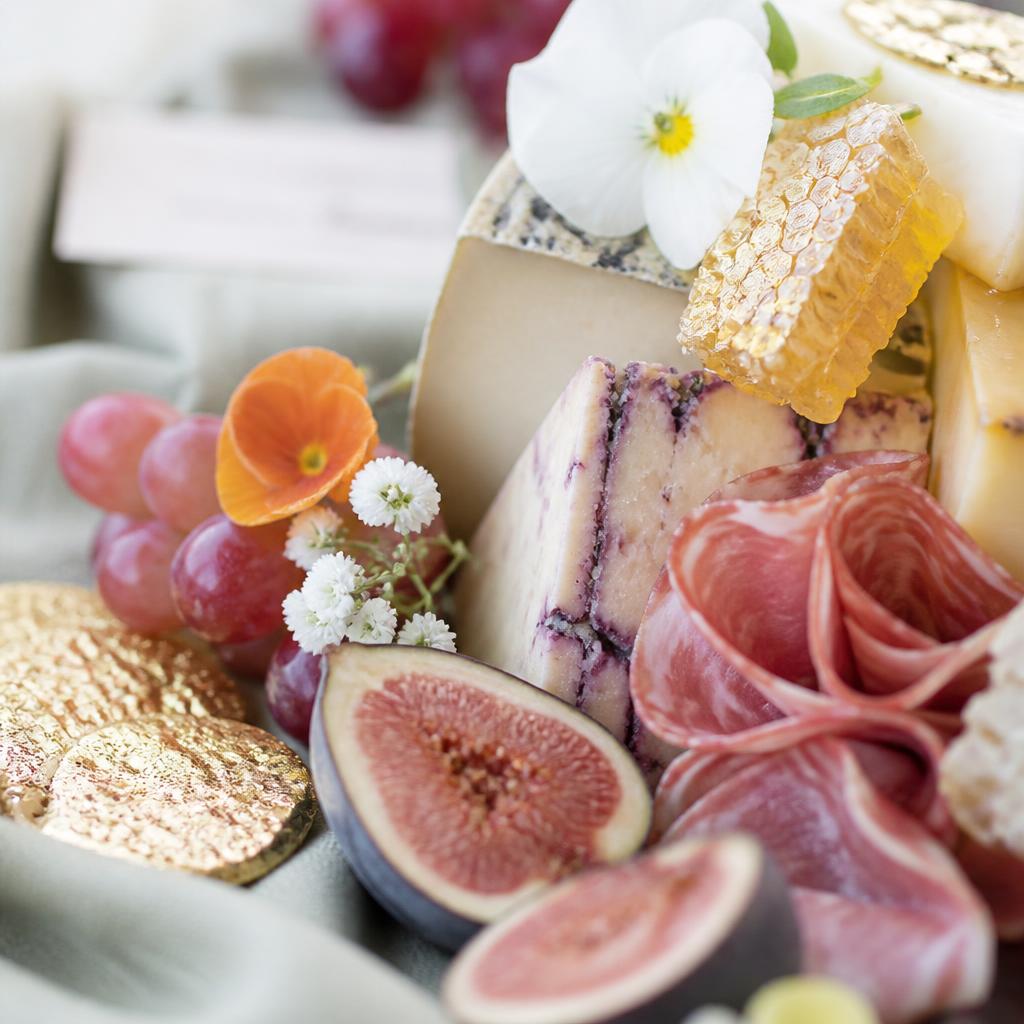 Close-up of a luxurious grazing table with honeycomb, artisan cheeses, and fresh figs